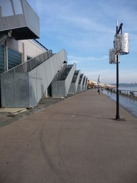 Road leading towards city against sky