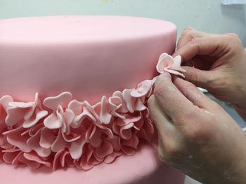  cropped hands of woman decorating cake