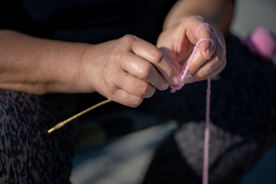 Cropped hand of woman knitting at home