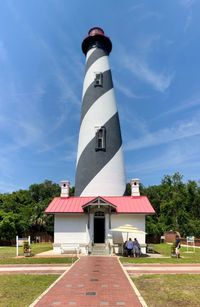 Lighthouse amidst buildings against sky