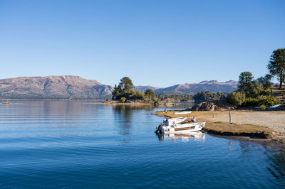 Scenic view of lake against clear blue sky