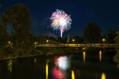 Reflection of firework display on river at night