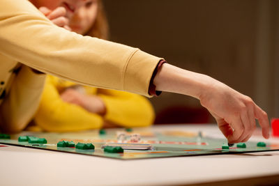 Midsection of people playing board game at home