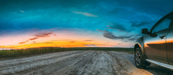 Car on road against sky during sunset