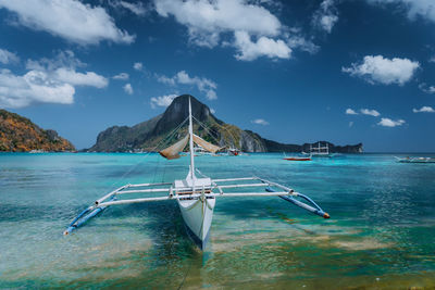 Sailboats in sea against sky