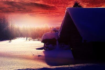 People on snow covered landscape at sunset