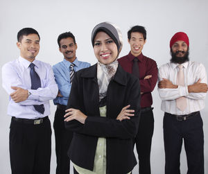 Portrait of smiling colleagues standing against white background