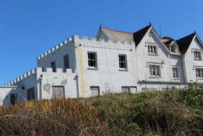 Low angle view of old building against clear blue sky