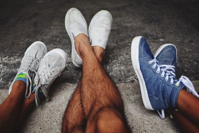 Low section of male friends wearing shoes