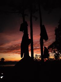 Silhouette people standing by tree against sky during sunset