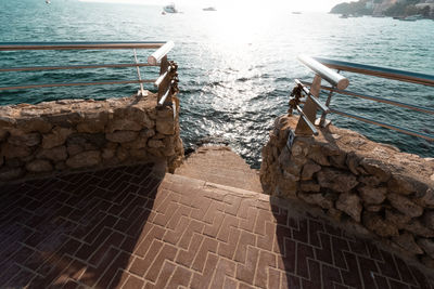 Stone wall by sea against sky