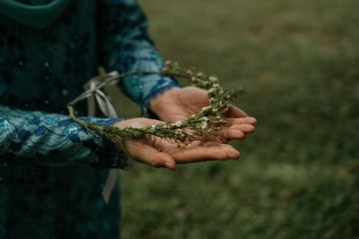 Midsection of woman holding flower decoration