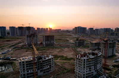 High angle view of buildings in city during sunset