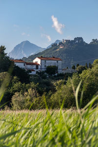 Scenic view of houses by mountains against sky