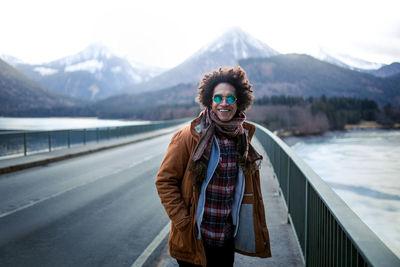 Portrait of young woman standing on snow covered mountain