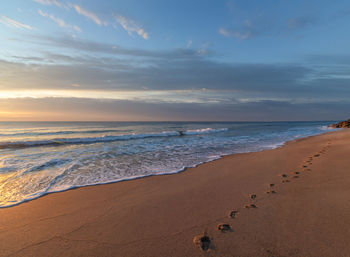 Scenic view of beach against sky during sunset