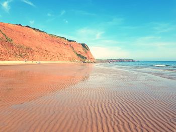 Scenic view of beach against blue sky