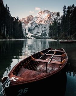 Boat moored by lake against sky during winter