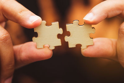 Cropped hands holding jigsaw puzzles