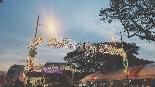 Low angle view of illuminated ferris wheel against sky