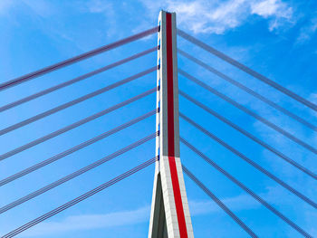 Low angle view of suspension bridge against blue sky