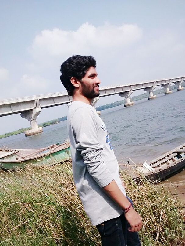 casual clothing, water, lifestyles, leisure activity, standing, person, sky, full length, pier, railing, wood - material, young adult, day, three quarter length, front view, nature, young men, looking away