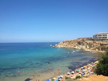 Scenic view of beach against clear blue sky