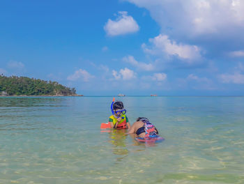 Mother and son in sea against sky