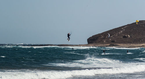 Man surfing in sea against clear sky