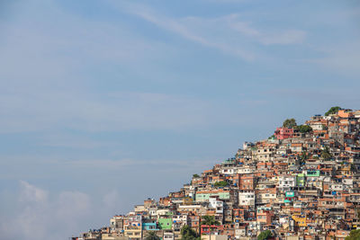 Low angle view of houses on mountain against sky