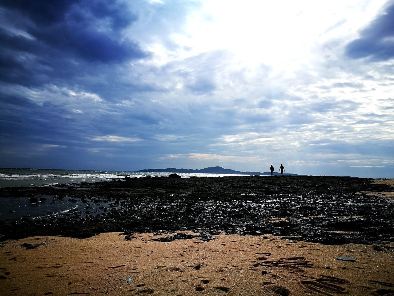 WOMAN ON BEACH AGAINST SKY