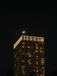 Low angle view of illuminated building against sky at night