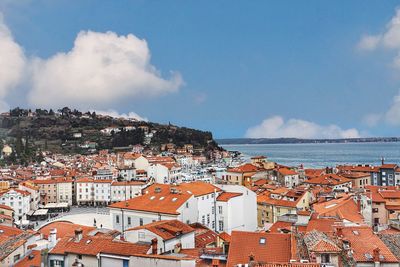 High angle view of townscape by sea against sky