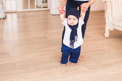 Low section of women standing on floor at home