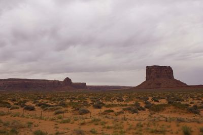 Rock formations on landscape against cloudy sky