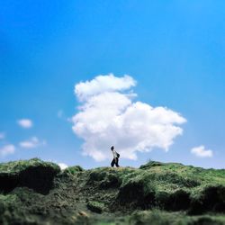 Man walking on mountain against sky