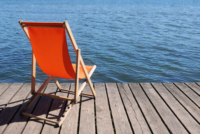 Empty chairs on pier