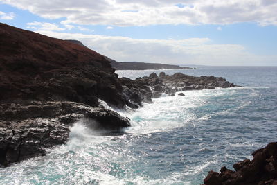 Scenic view of rock formation and sea against sky