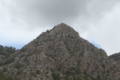 Low angle view of rocky mountain against sky