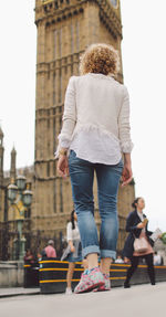 Full length rear view of woman standing against big ben