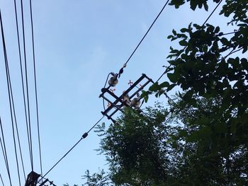 Low angle view of electricity pylon against blue sky