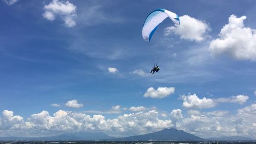 Low angle view of paragliding against sky