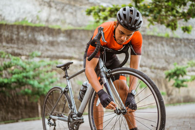 Rear view of man riding bicycle on street