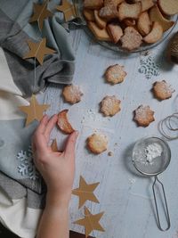 High angle view of hand holding cookies on table