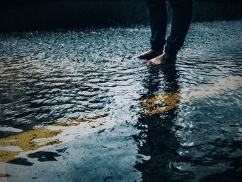 Low section of man with reflection in water