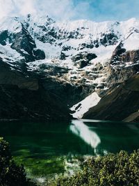 Scenic view of lake by snowcapped mountains