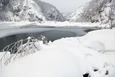 Scenic view of frozen lake by snowcapped mountains