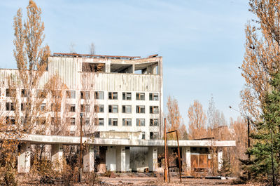 Old building by trees against sky