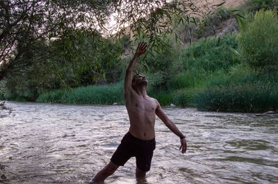 Full length of shirtless man standing in water