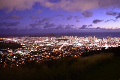 High angle view of illuminated city buildings against sky at night